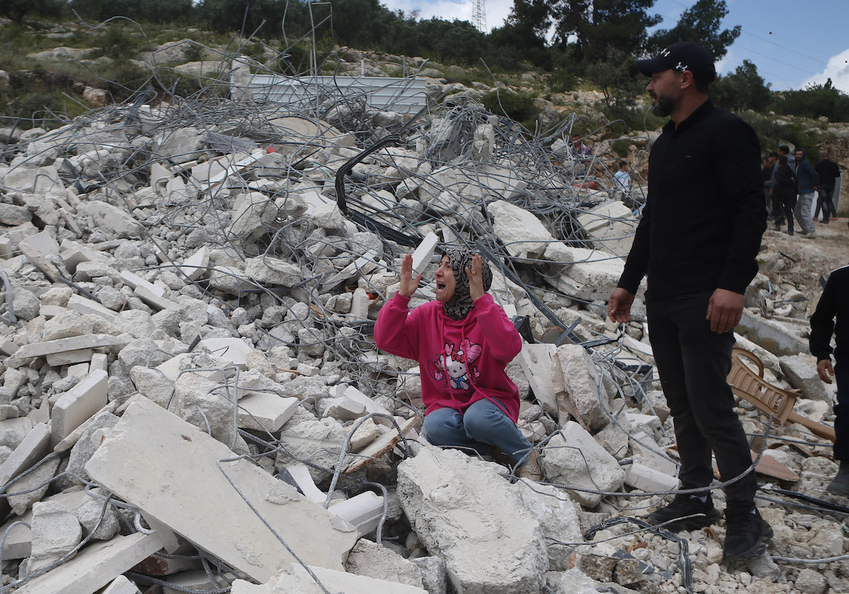 A woman cries in the rubble of the building after heavy machines belonging to the Israeli army demolished a two-story Palestinian building under the pretext that it was constructed without a permit in the Hebron, West Bank, Palestine on April 20, 2026, [Wisam Hashlamoun - Anadolu Agency]