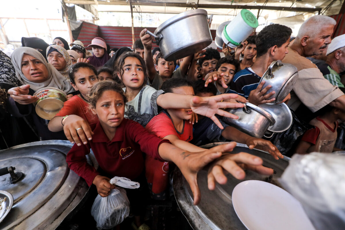 Palestinians, including children, gather to receive hot meals distributed at a food aid point in the Nuseirat Refugee Camp in central Gaza, Palestine, on June 22, 2026. [Moiz Salhi - Anadolu Agency]