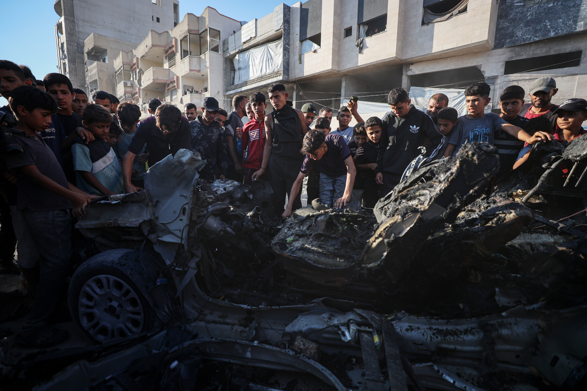 Palestinians inspect a vehicle destroyed in an Israeli strike in Gaza City, Gaza, Palestine, on July 8, 2026. [Abdalhkem Abu Riash - Anadolu Agency]
