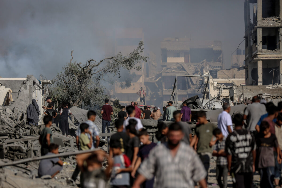 Palestinians rush as smoke rises among rubble and destruction on Al-Sinaa (Industrial) Street in western Gaza City on July 12, 2026, after the Israeli military targeted several buildings using unmanned aerial vehicles (UAVs). [Saeed M. M. T. Jaras - Anadolu Agency]